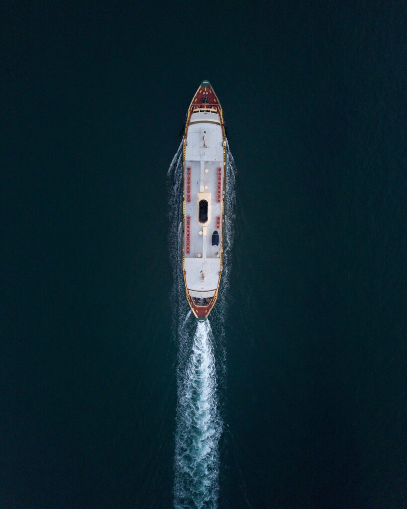 pexels photo 1556991 1556991 Top-down view of a ferry cruising through Sydney waters, creating rippling waves.